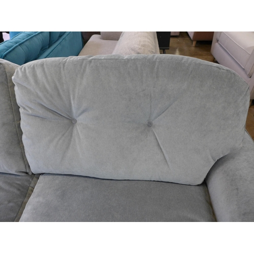 1302 - A grey velvet three seater sofa on turned legs