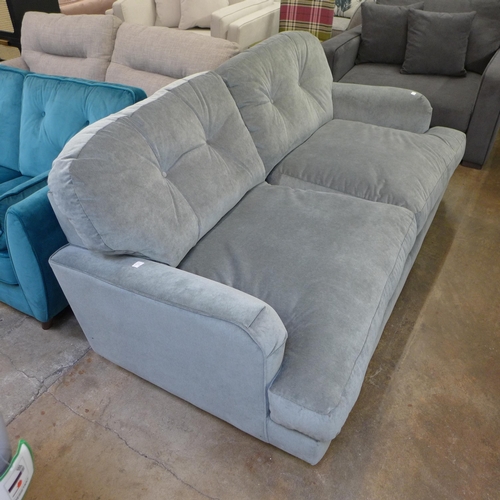 1302 - A grey velvet three seater sofa on turned legs