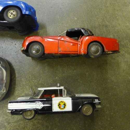 726 - A Japanese tin plate TR3 sports car, Police Car and two more vehicles