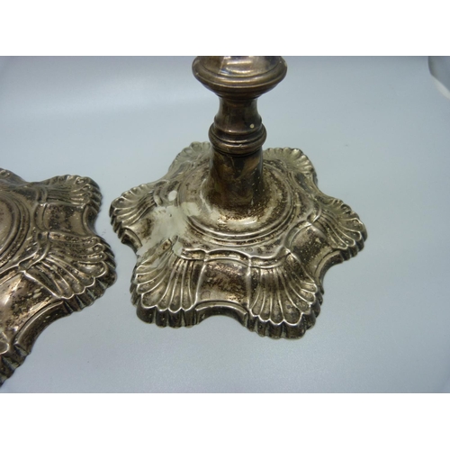 850 - Two silver candlesticks, one marked London 1762,  one marked London 1777, total weight 1079g