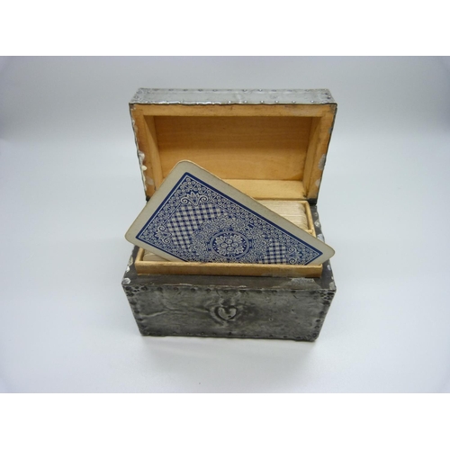 875 - An Arts and Crafts metal covered playing card box, containing two packs of playing cards