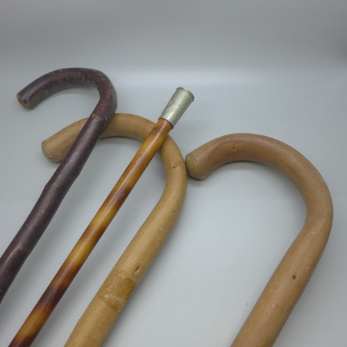 820 - A military swagger stick, The Green Jackets emblem, and three other wooden walking sticks