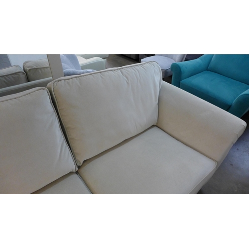 1400 - An ivory velvet three seater sofa