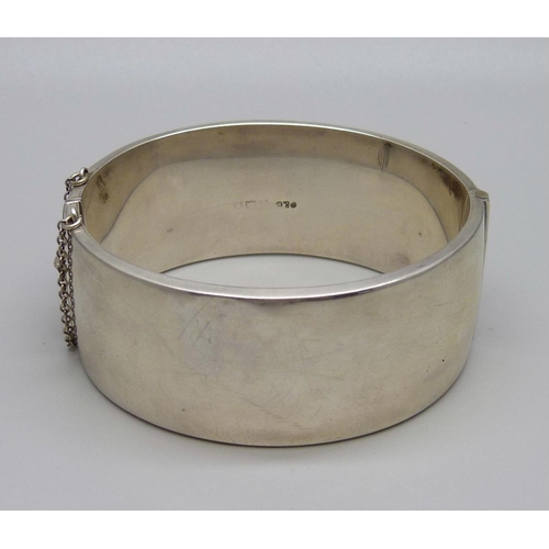 1019 - A wide hallmarked silver bangle with engraved decoration, 34g