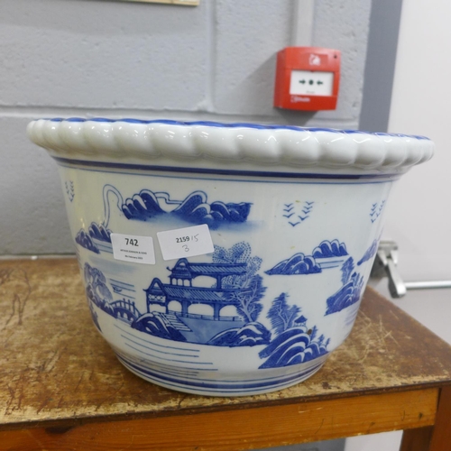 742 - A Chinese style blue and white jardiniere with four feet, 36.5cm diameter