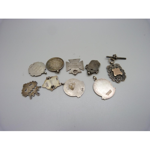 782 - Eight silver medallions and fobs including an enamelled rugby fob, 74g, and one other fob