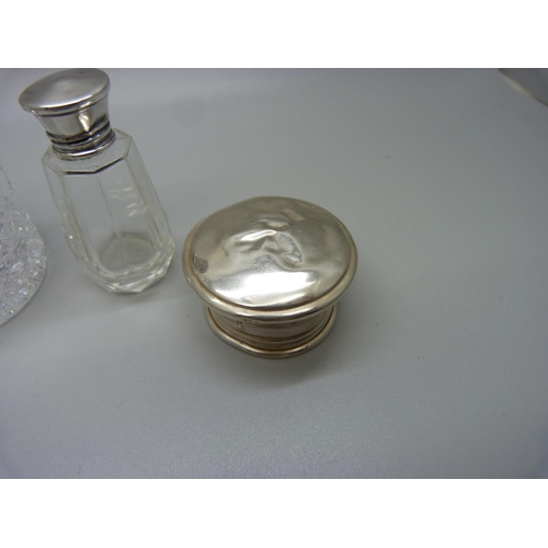 805 - A silver topped glass scent bottle with inner stopper, a silver topped glass jar, a cut glass bottle... 