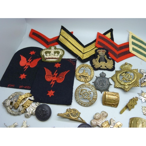 817 - A collection of Regimental cap badges, cloth badges and buttons