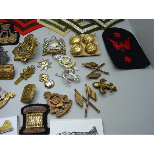 817 - A collection of Regimental cap badges, cloth badges and buttons