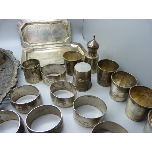 833 - A collection of white metal items; two small trays, fourteen napkin rings, three piece condiment, si... 