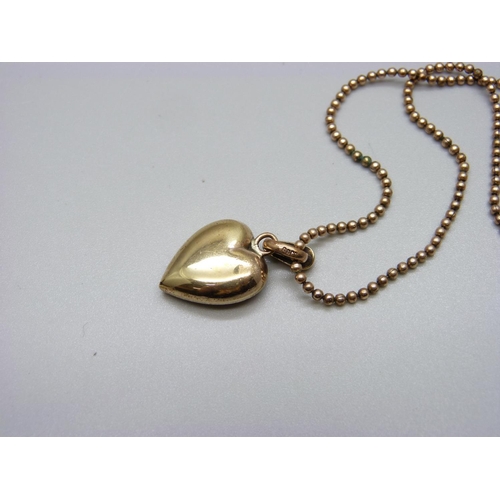 867 - A yellow metal heart shaped pendant set with pearls, green and red stones on a 9ct gold bead  chain,... 