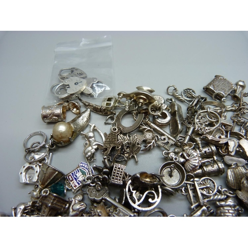 942 - A collection of silver and white metal charms, 204g