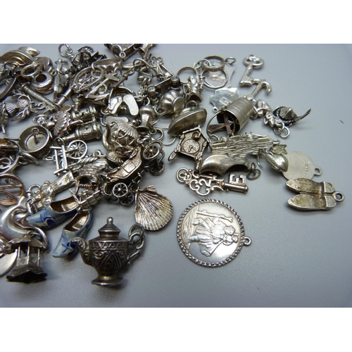 942 - A collection of silver and white metal charms, 204g