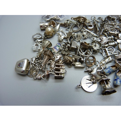 942 - A collection of silver and white metal charms, 204g