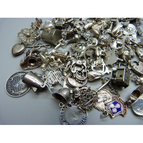 943 - A collection of silver and white metal charms, 235g