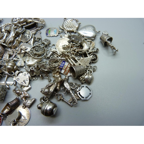 943 - A collection of silver and white metal charms, 235g