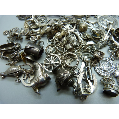 945 - A collection of silver and white metal charms, 201g