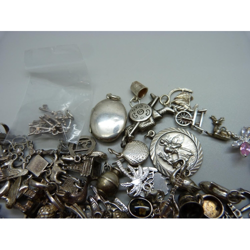 945 - A collection of silver and white metal charms, 201g