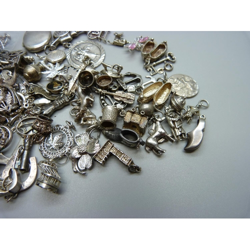 945 - A collection of silver and white metal charms, 201g