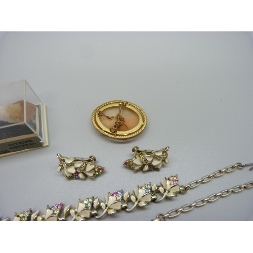 956 - A 9ct rolled gold cameo brooch, a costume necklace and earrings set and a citrine crystal