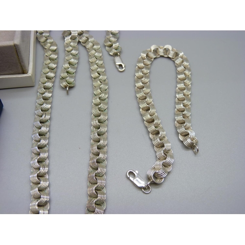 957 - A silver necklace and bracelet, a small silver pendant and a silver necklace and earring set