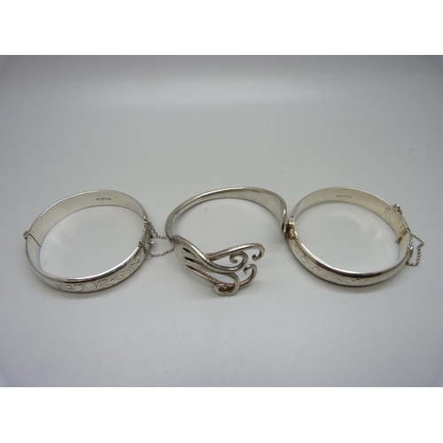 983 - Two hallmarked silver engraved bangles and safety chains, Birmingham 1974, 20g and 1969, 19.3g and o... 