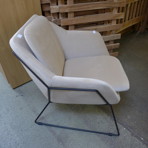 1446 - A beige velvet armchair on metal frame