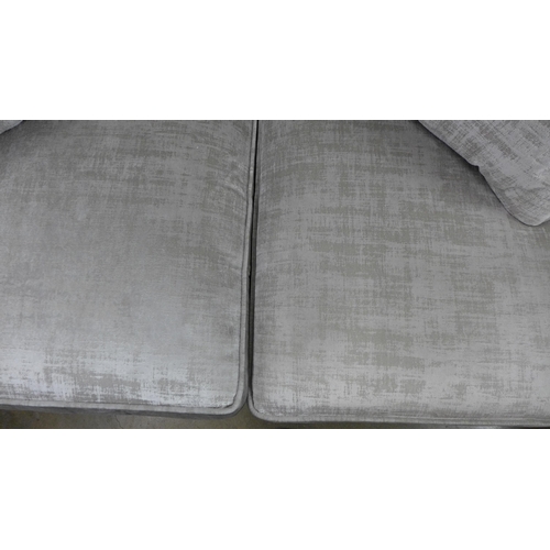 1447 - A stone velvet three seater sofa