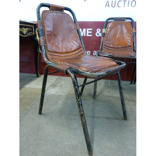 1 - A set of four Les Arcs style black metal and brown leather chairs, attributed to Charlotte Perriand