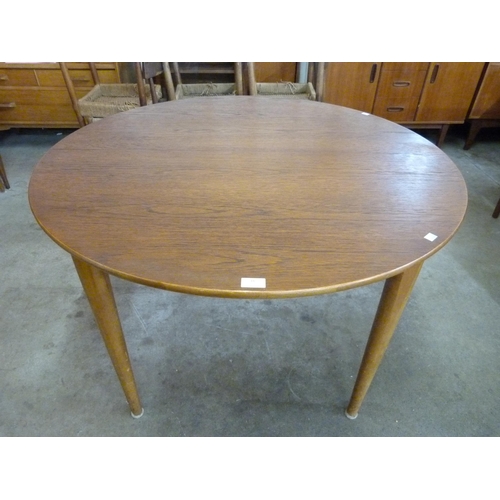 16 - A teak circular extending dining table