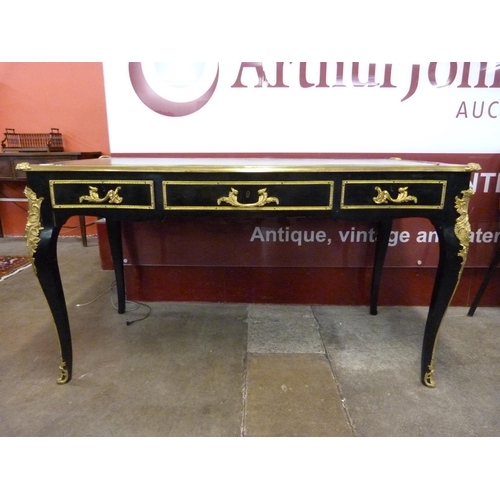 75 - A French ebonised, ormolu and green leather topped three drawer writing table