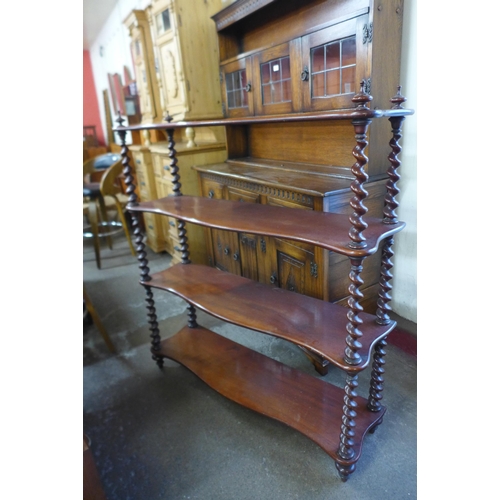 598 - A Victorian mahogany serpentine four tier barleytwist whatnot