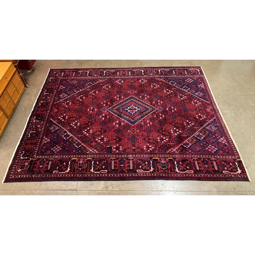 37 - An eastern red ground rug, 325 x 240cms