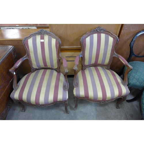 153 - A pair of French carved beech and fabric upholstered fauteuil armchairs