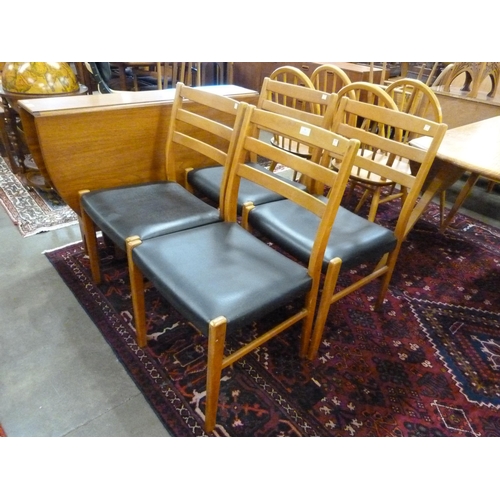 71 - A set of four teak and black vinyl dining chairs