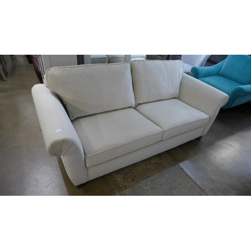 1375 - An ivory velvet three seater sofa