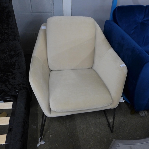 1410 - A beige velvet armchair on metal frame