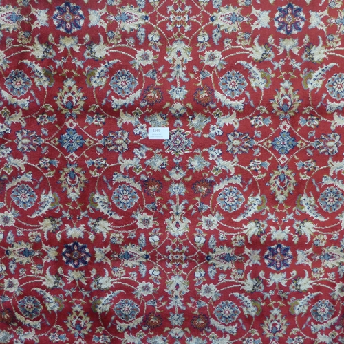 1569 - A red ground full pile Cashmere rug, all over floral design, 170cm x 120cm