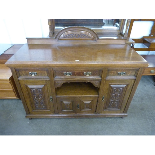 106 - An Arts and Crafts carved oak sideboard