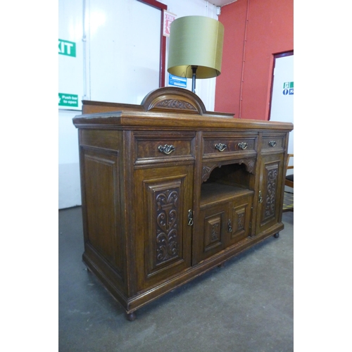 106 - An Arts and Crafts carved oak sideboard