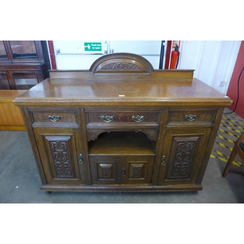 106 - An Arts and Crafts carved oak sideboard