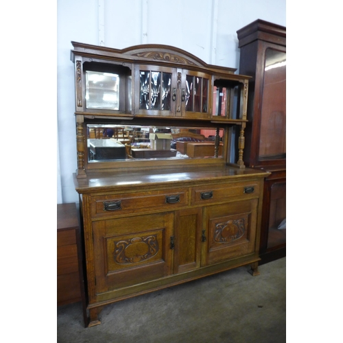 108 - An Arts and Crafts carved oak mirrorback sideboard