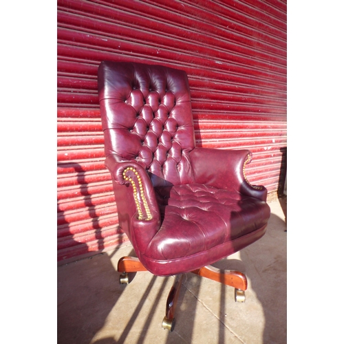 112 - A Chesterfield style burgundy leather revolving desk chair