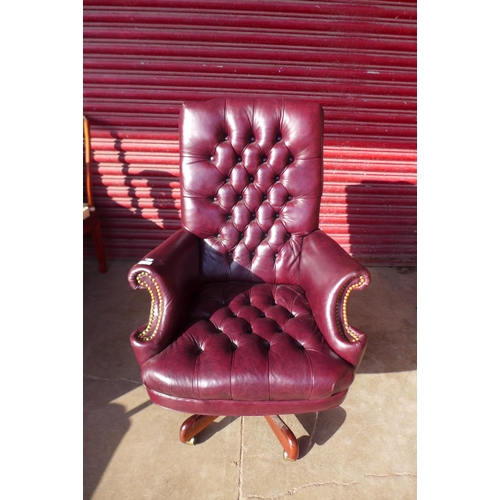 112 - A Chesterfield style burgundy leather revolving desk chair