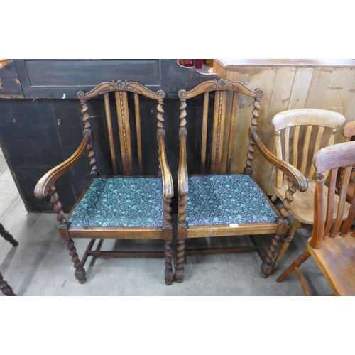 131 - A pair of early 20th Century oak barleytwist elbow chairs