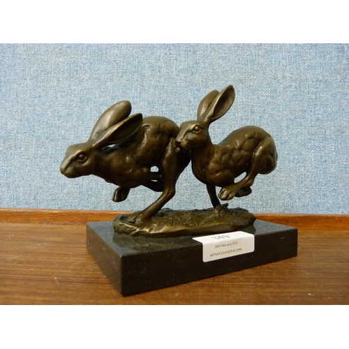 349 - A small bronze figure of two hares, on black marble socle