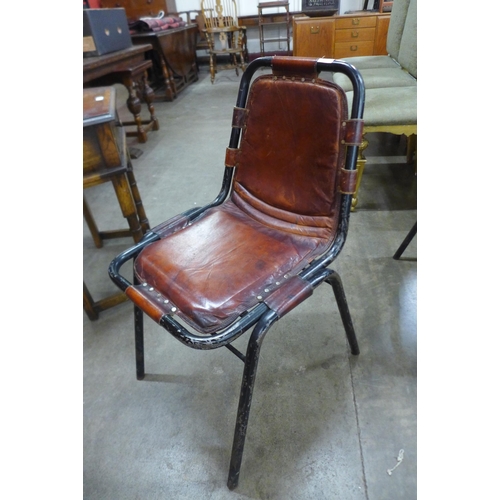 51 - A set of four Les Arc style black metal and brown leather chairs, attributed to Charlotte Perriand