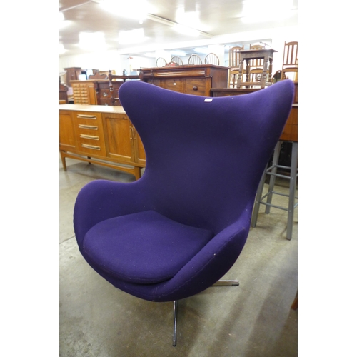 59 - An Arne Jacobsen style chrome and purple fabric revolving lounge chair