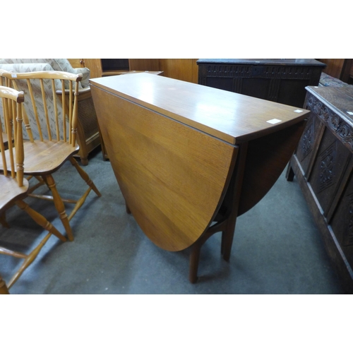 63 - A teak drop-leaf table