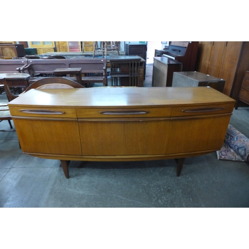 73 - A teak bow front sideboard